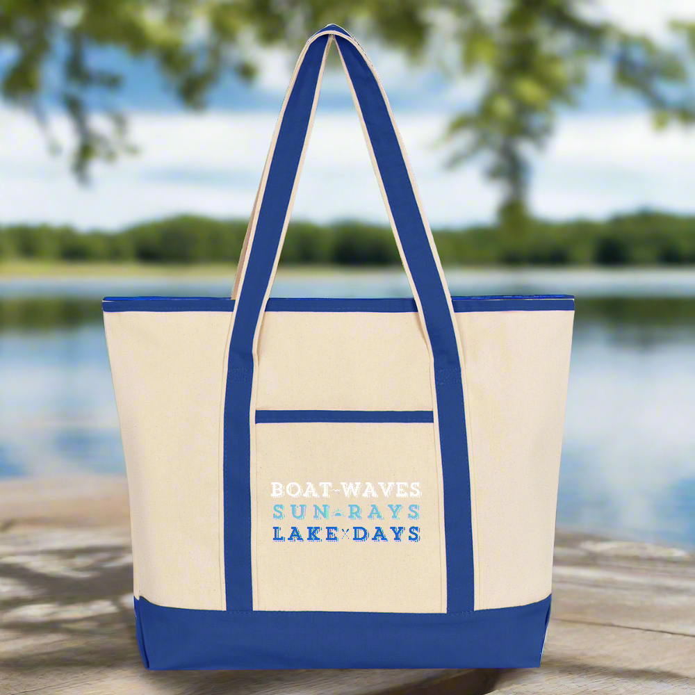 Boat Waves, Sun Rays, Lake Days Tote Bag - Beige Bag with Royal Blue Accents and Straps - sitting on wooden dock