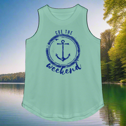 Mint green tank top with blue anchor design and text 'Cue the weekend' against a scenic lake background